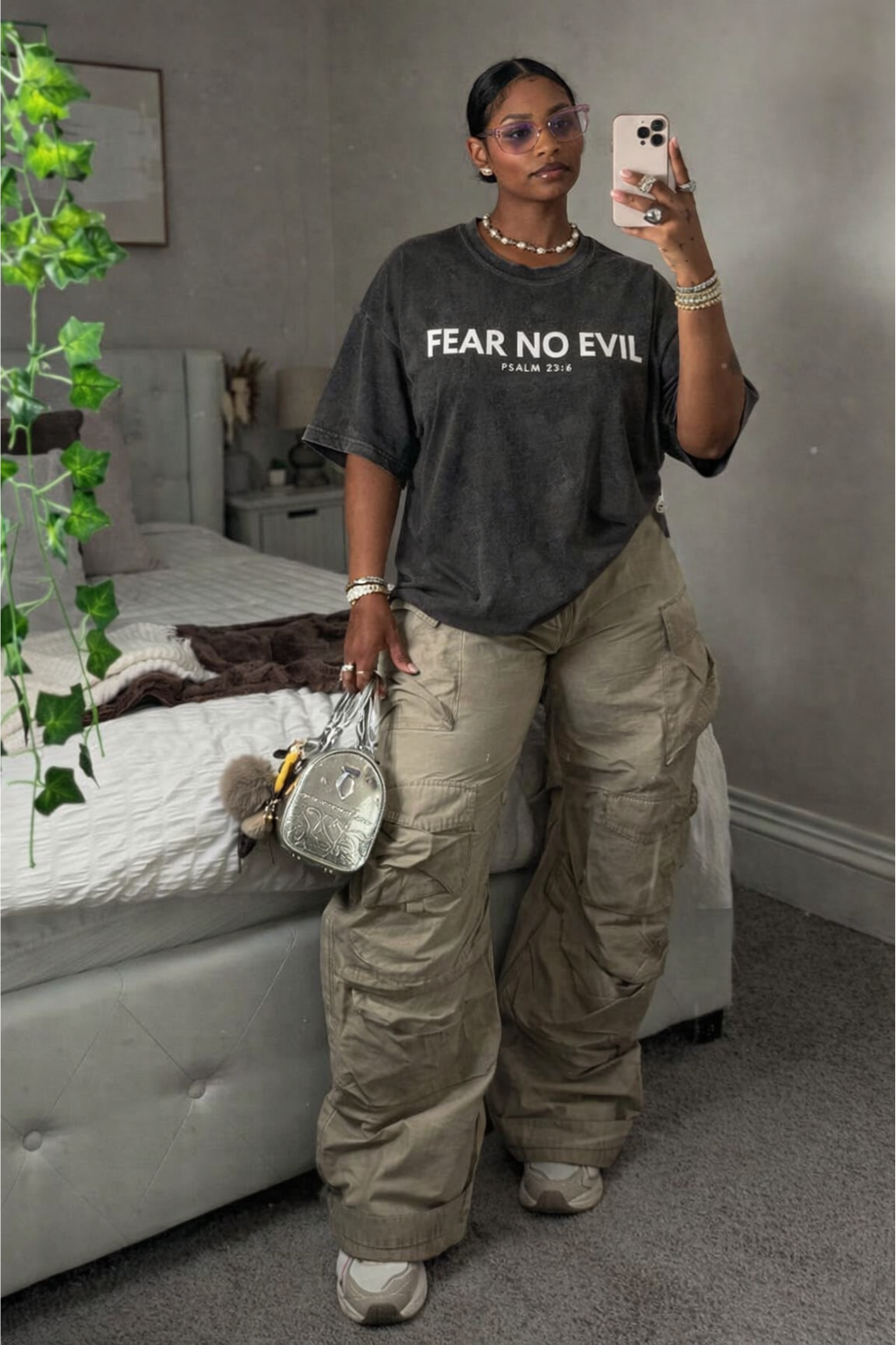 Person wearing a 'Fear No Evil' t-shirt in a bedroom setting
